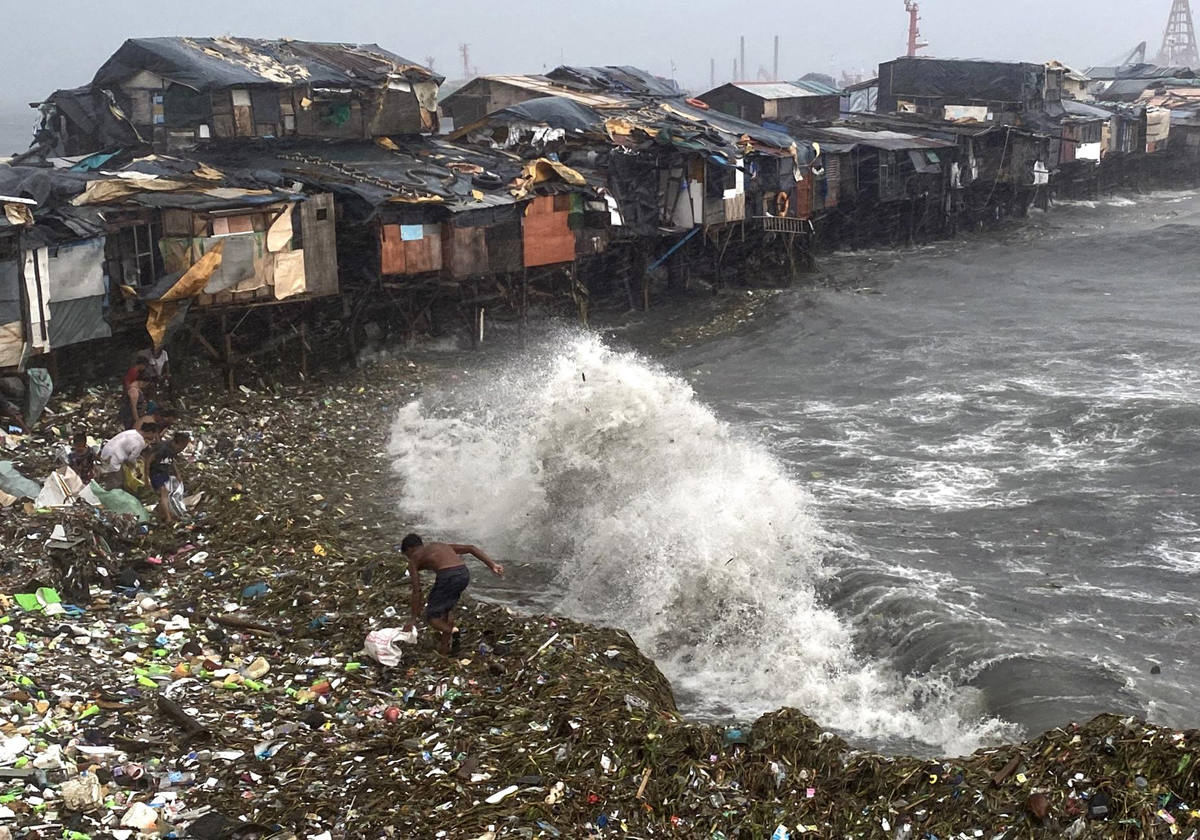 Un hombre se ve sorprendido por una ola mientras rescata materiales desperdigados por la orilla en Manila Bay,Filipinas, este miércoles. Al menos una persona ha fallecido y más de 180.000 se han visto afectadas por el impacto del supertifón Doksuri en Filipinas, según informó este miércoles el Instituto Nacional de Gestión y Reducción del Riesgo de Desastres (NDRRMC, por sus siglas en inglés) del archipiélago asiático.