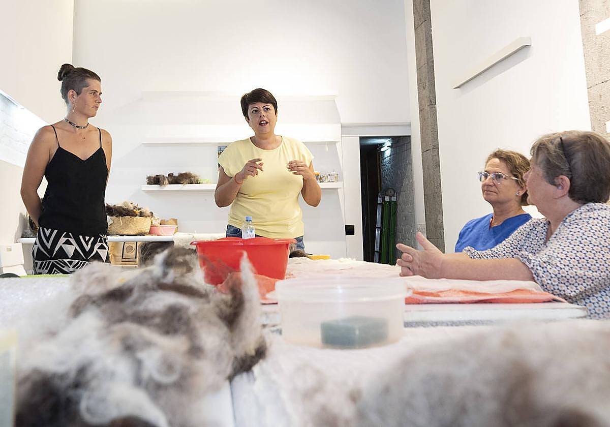 Minerva Alonso (centro) y la artesana Boncke, ambas de pie, en La Sala de la Fedac.