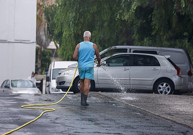 Un residente se encarga de limpiar la calle.