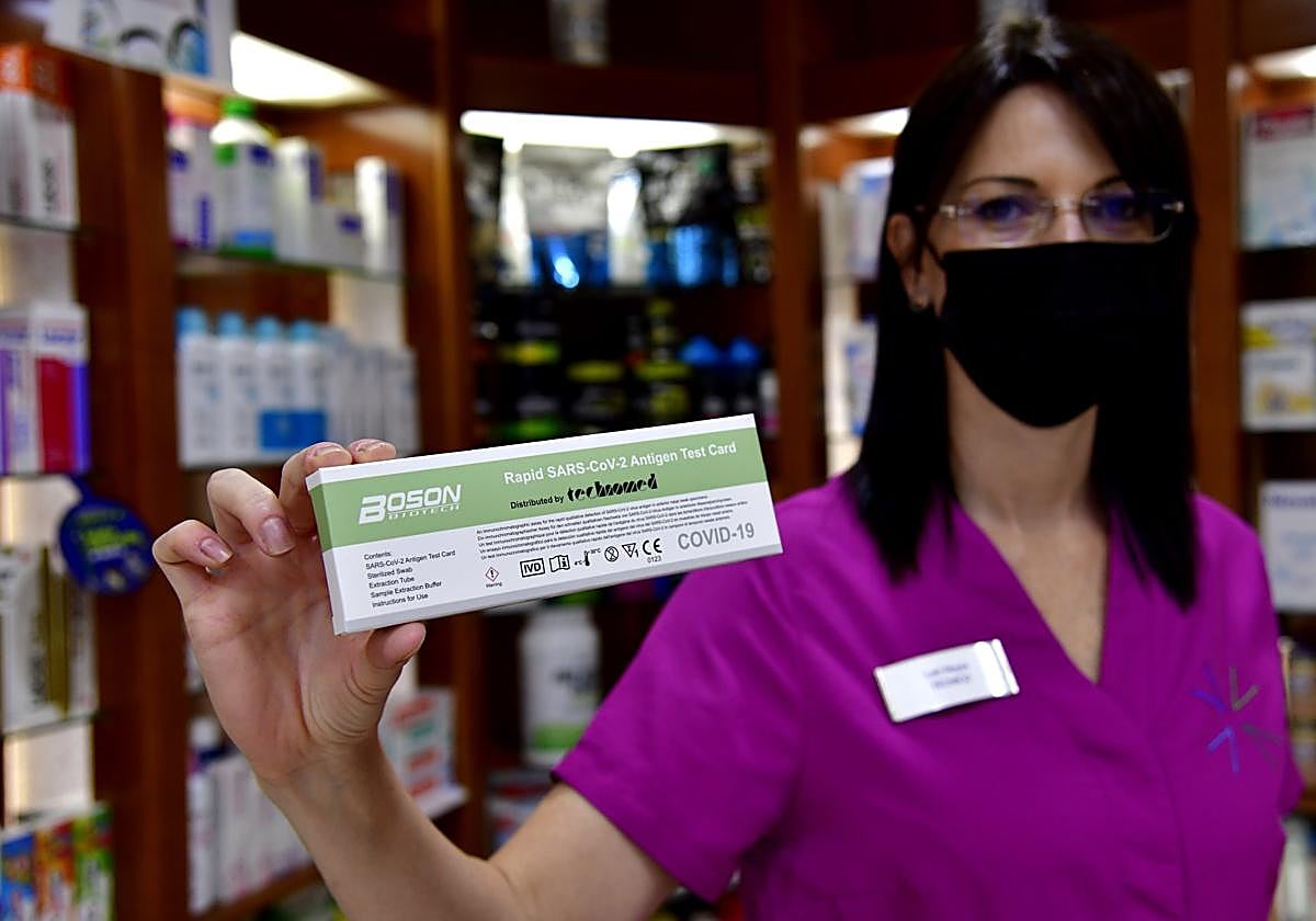 Foto de archivo de una boticaria con un test de antígenos.