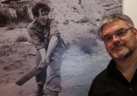 El escritor Jorge Fonte posa delante de una foto de John Lennon, el beatle que faltó al viaje a Tenerife, en 1963.