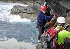 Ángela Santana Molina recorriendo una vía ferrata por un cantil muy vertical, en la costa de la isla.