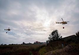 Dos helicópteros sobrevuelan un foco situado en El Ravelo, en el municipio de El Sauzal, una de las zonas afectadas por el incendio forestal declarado el pasado martes en Tenerife.
