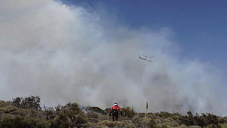 Un helicóptero trabaja en la extinción del incendio forestal en los altos de Güímar.