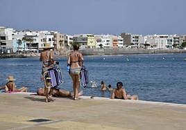 Muchos sobrellevan el calor aprovechando un poco de brisa en Arinaga y dándose un baño en el mar.