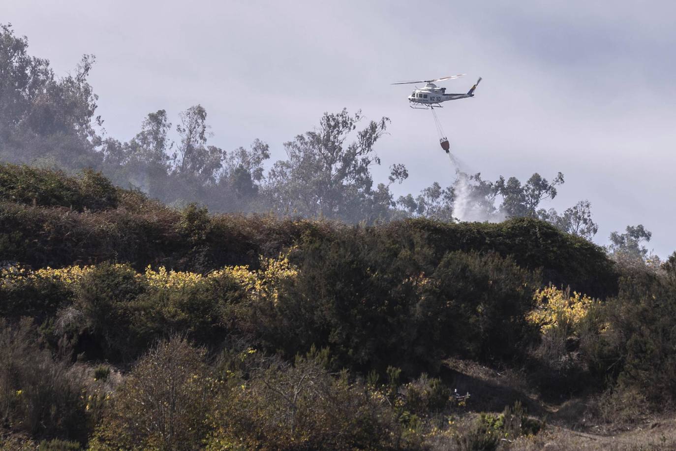 Imagen de un helicóptero refrescando la zona del incendio forestal en el municipio tinerfeño de Santa Úrsula el pasado viernes.