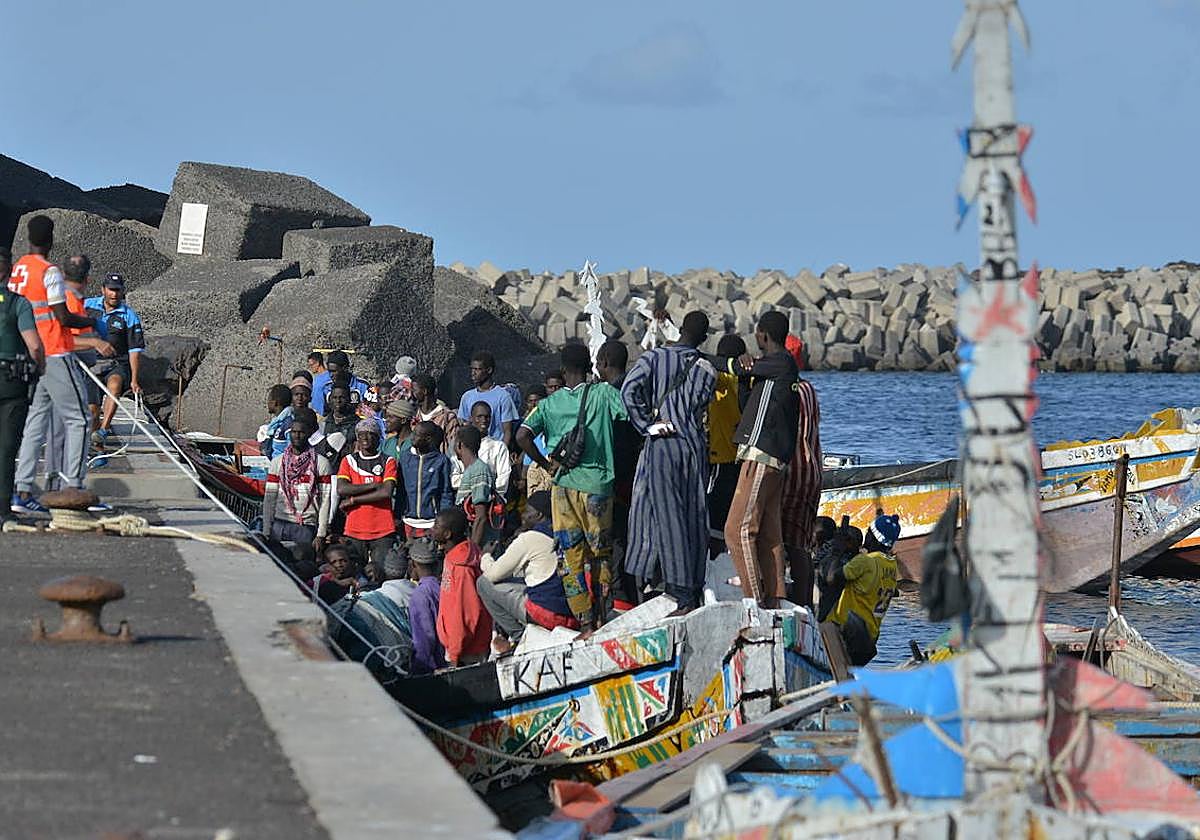 Trabajadores de la Cruz Roja al lado de un cayuco.