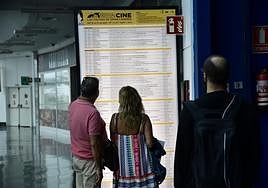 Una pareja consulta el cartel del festival de cine.