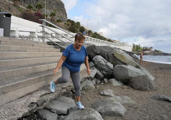 Loli se apoya sobre una piedra para llegar a la arena.