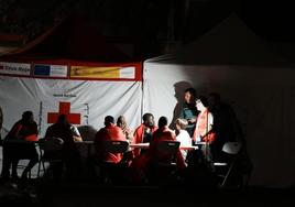 Miembros de Cruz Roja Española junto a varios migrantes a su llegada a la isla de El Hierro.