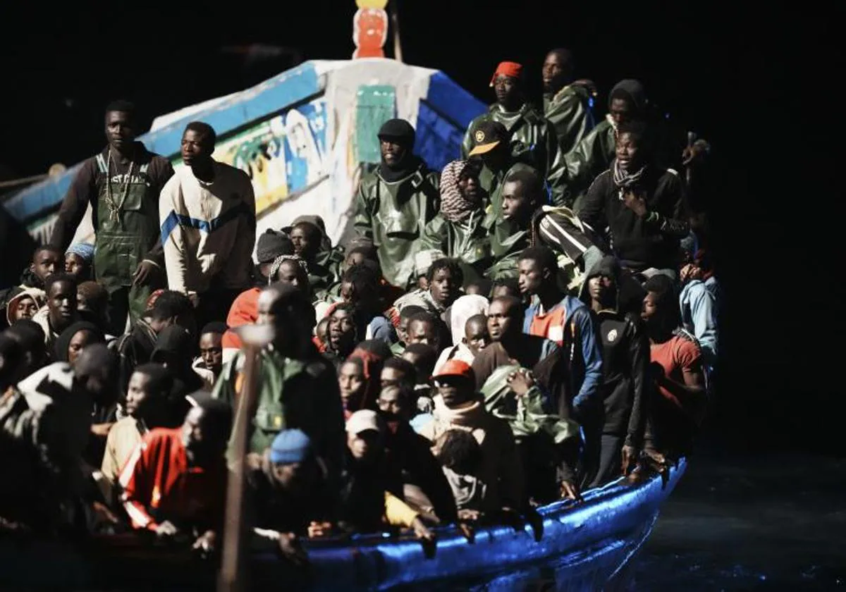 Decenas de personas en un cayuco a su llegada al muelle de La Restinga, en una imagen reciente en la Isla de El Hierro.