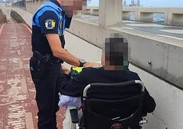 El hombre en silla de ruedas eléctrica acompañado de un agente de la Policía Local.