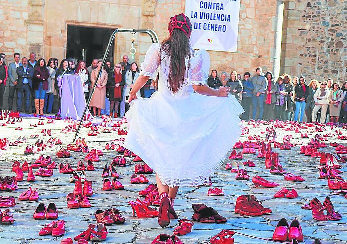 Las pisadas de la ausentes, en forma de zapatos rojos, alientan la lucha contra la violencia machista en una performance organizada en Cáceres.