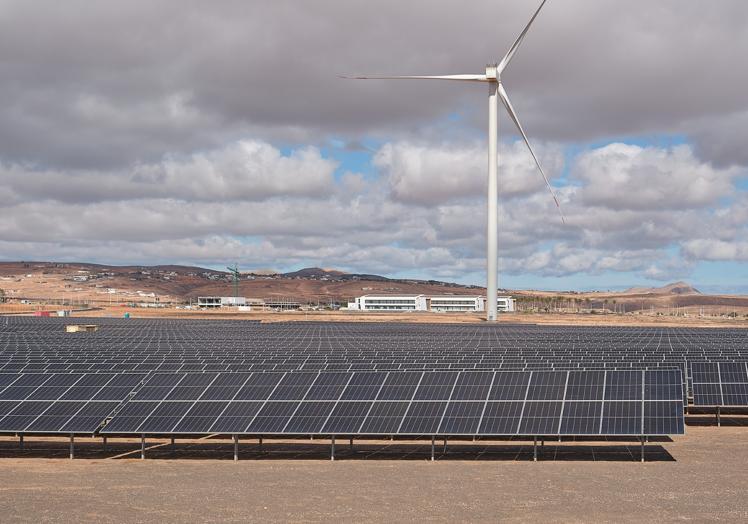 Paneles solares y aerogenerador, con el Parque Tecnológico al fondo, en el acceso a Puerto del Rosario.