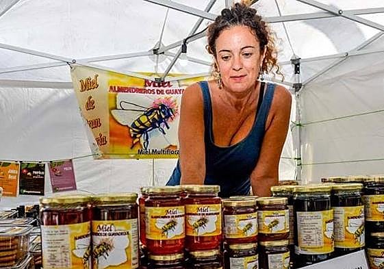 Ysaura González, junto a los botes de su miel, en una feria reciente.