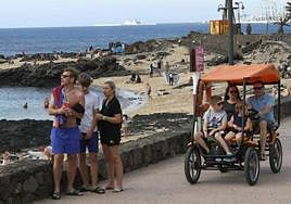 Un grupo de turistas pasean por el núcleo turístico de Costa Teguise, en Lanzarote.