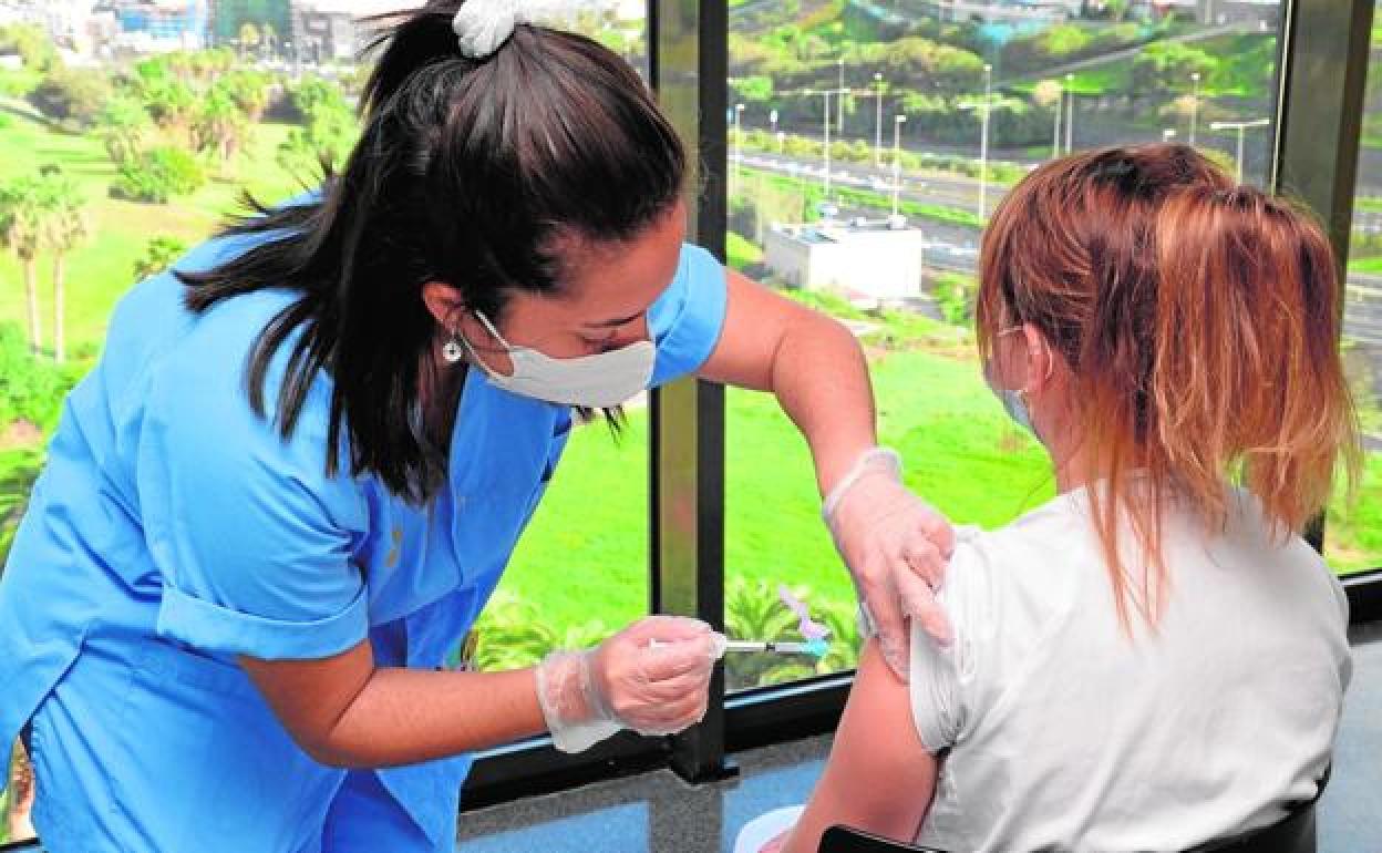 Una sanitaria vacuna a otra en el hospital Doctor Negrín de Gran Canaria, uno de los puntos de administración de la AstraZeneca.