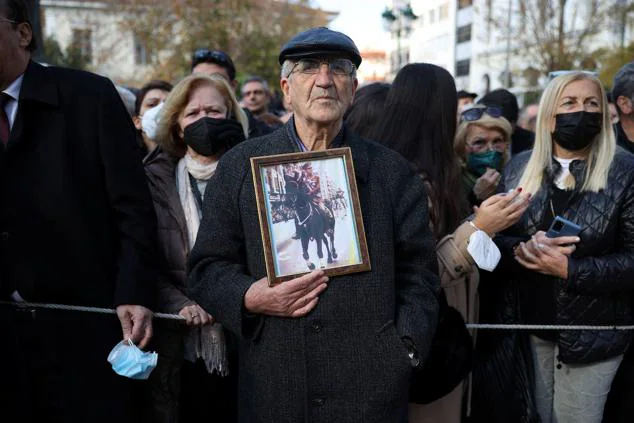 Un hombre sostiene una foto de Constantino II durante su funeral en Atenas. 
