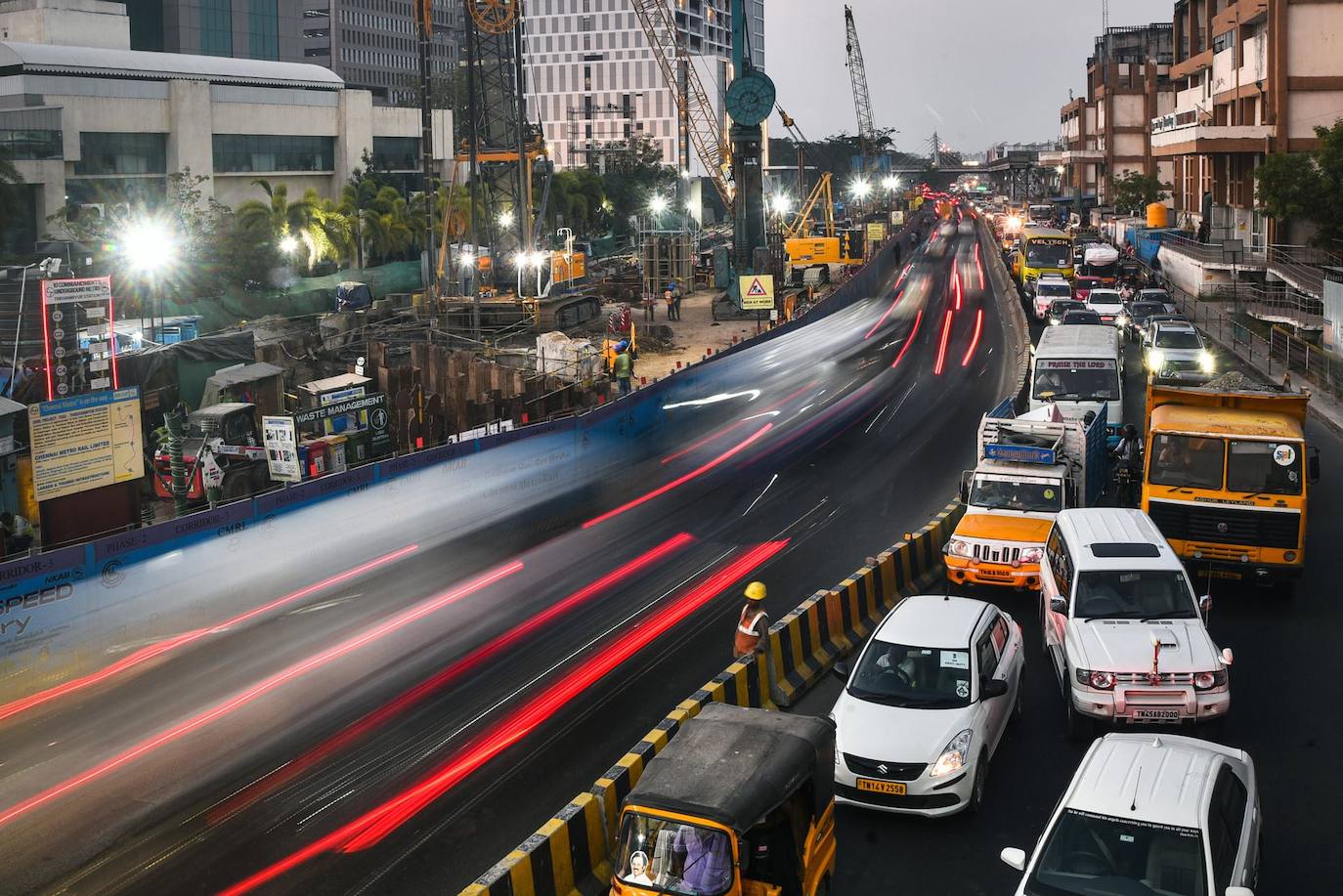 Un trabajador permanece junto a una mediana en obras mientras cientos de vehículos pasan por una concurrida calle de Chennai, India, este martes. India ocupa el segundo lugar en la lista de los países más poblados del mundo (superado por China) y cuenta con un total 1.415.199.835 habitantes a fecha de este mismo martes. 