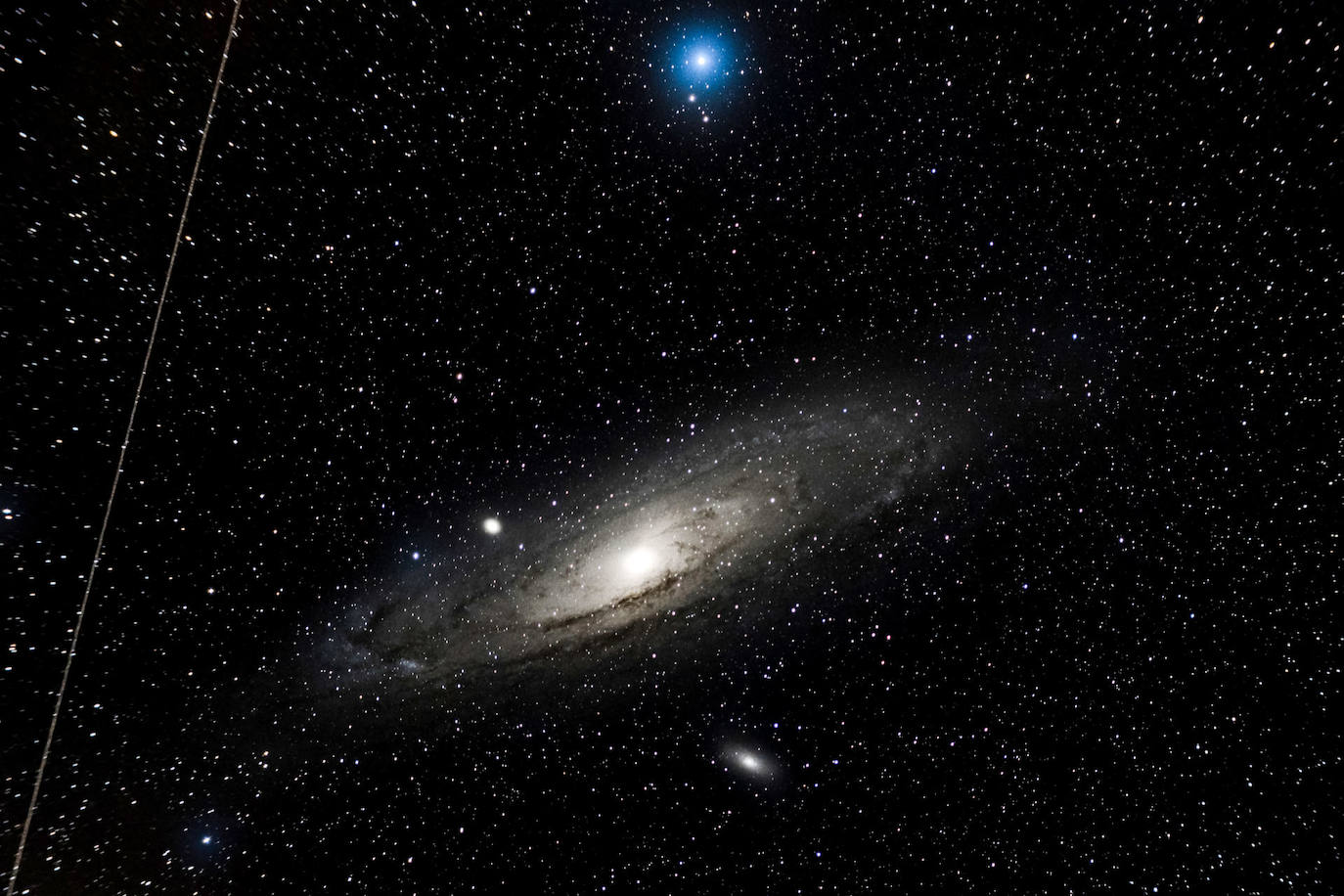 Imagen compuesta por la integración de una hora de exposiciones fotográficas que muestran la galaxia de Andrómeda, a unos 2,5 millones de años luz de distancia y un satélite artificial (i), desde la localidad cántabra de La Hayuela. 
