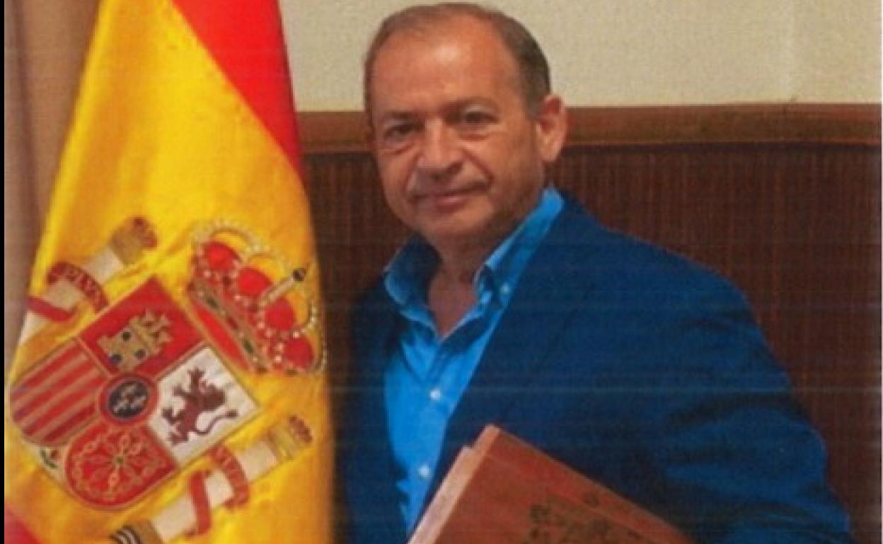 En la imagen, el general Francisco Espinosa, con una caja de puros ante la bandera de España.