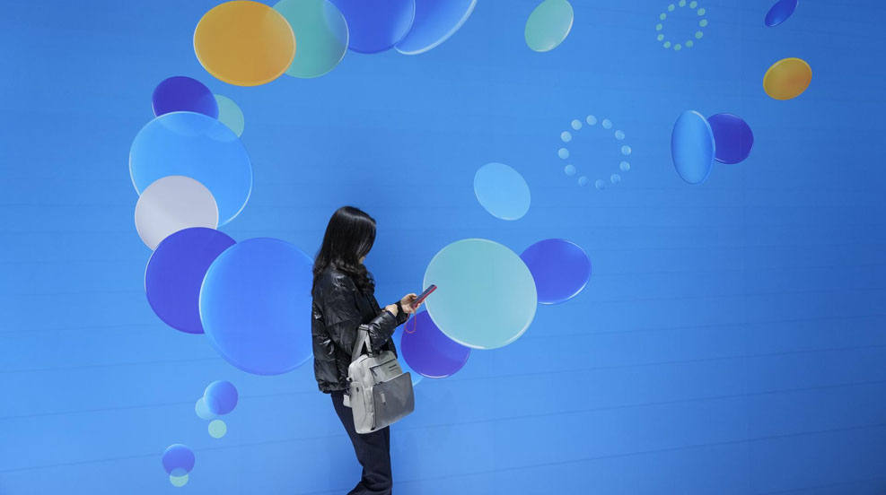 Una visitante recorre el Mobile World Congress (MWC), el mayor evento de tecnología móvil del mundo, que arranca en Barcelona en un clima ya de plena normalidad tras las ediciones de la covid y que prevé atraer a más de 80.000 congresistas. 