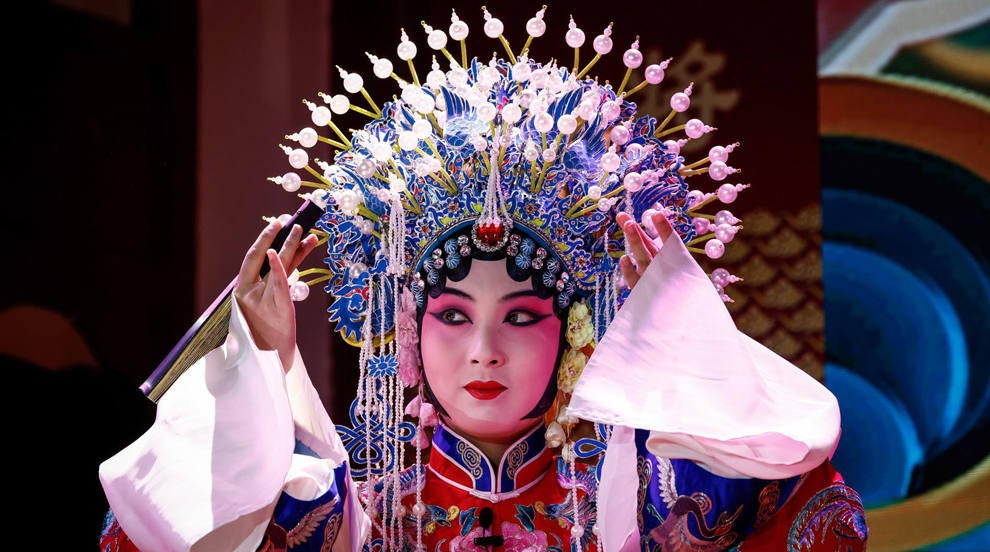 Una mujer vestida con un traje de la Ópera de Pekín actúa durante una gira mediática por el Parque Qianmen Sanlihe en Pekín, China. El Parque Qianmen Sanlihe se remonta a la Dinastía Ming donde era un canal de descarga de inundaciones con residentes que vivían cerca con salas de teatro y gremios. 