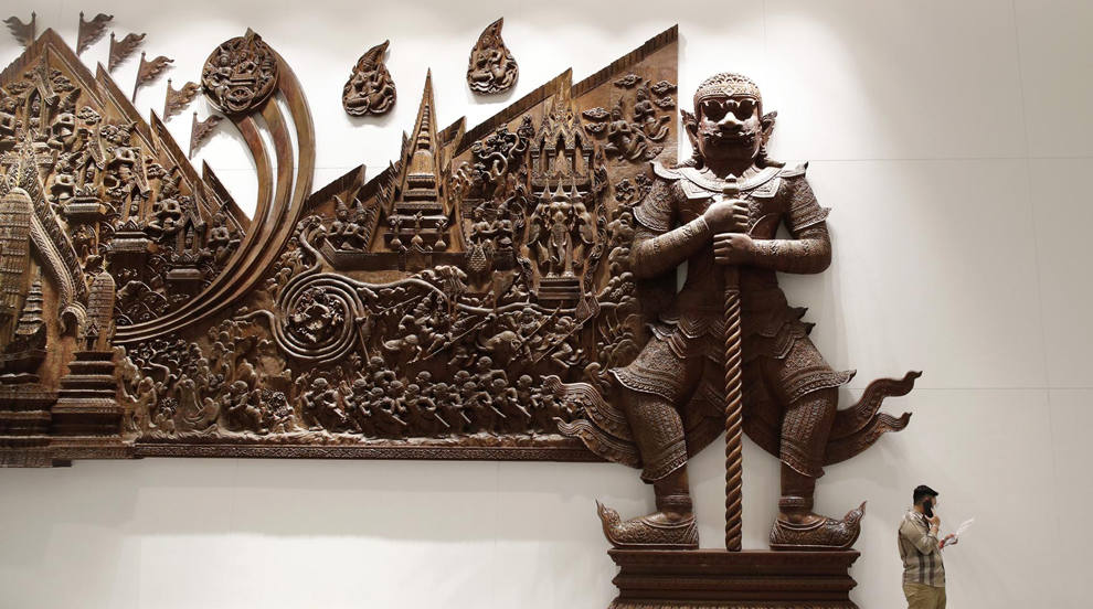 Un visitante habla por su teléfono móvil mientras consulta ofertas de viajes en una feria de turismo y viajes en Bangkok, Tailandia. La feria de turismo y viajes cuenta con cientos de expositores de operadores turísticos, hoteles y agencias de viajes que ofrecen descuentos en un intento de reactivar la industria turística del país e impulsar su economía. 