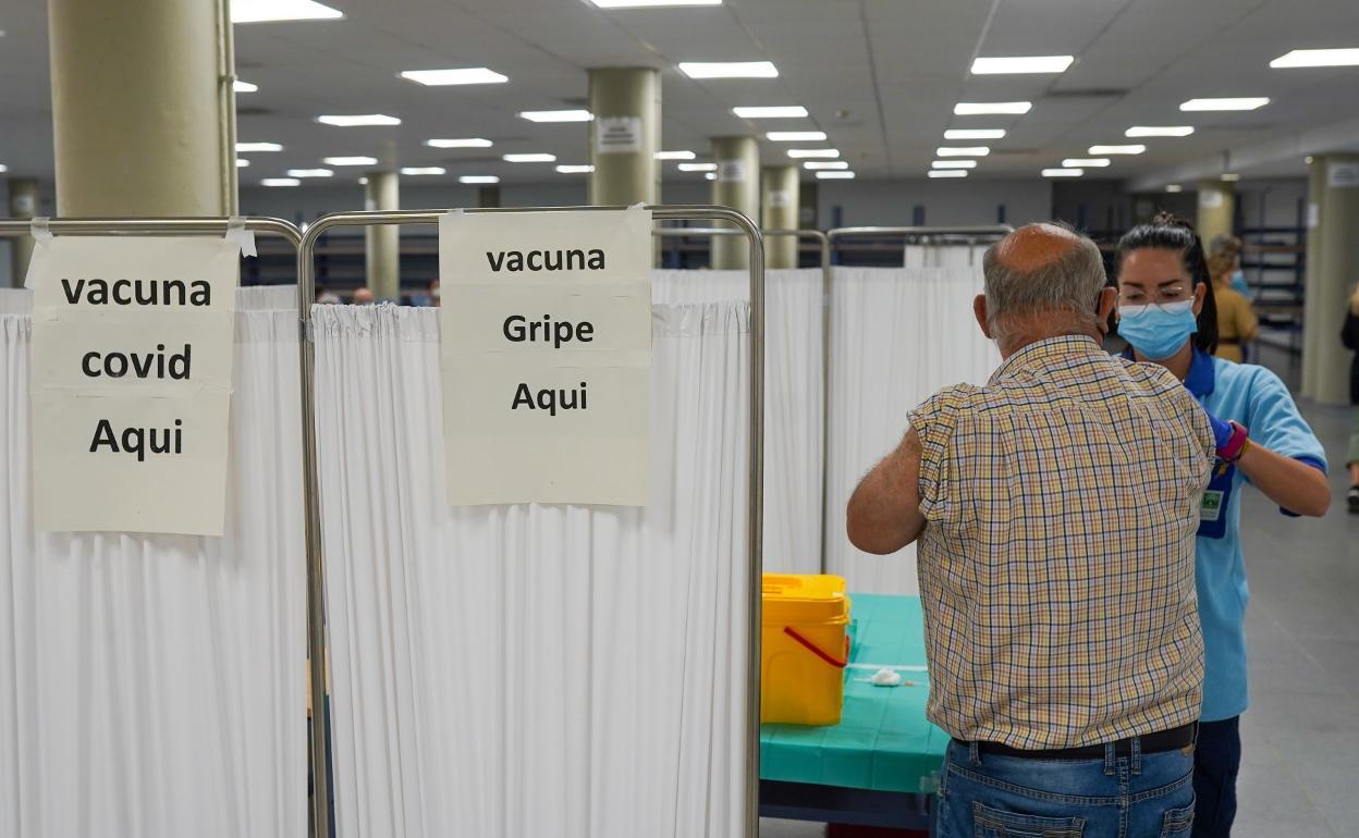 Imagen de archivo de un hombre que va a recibir la doble vacunación contra la covid y la gripe.