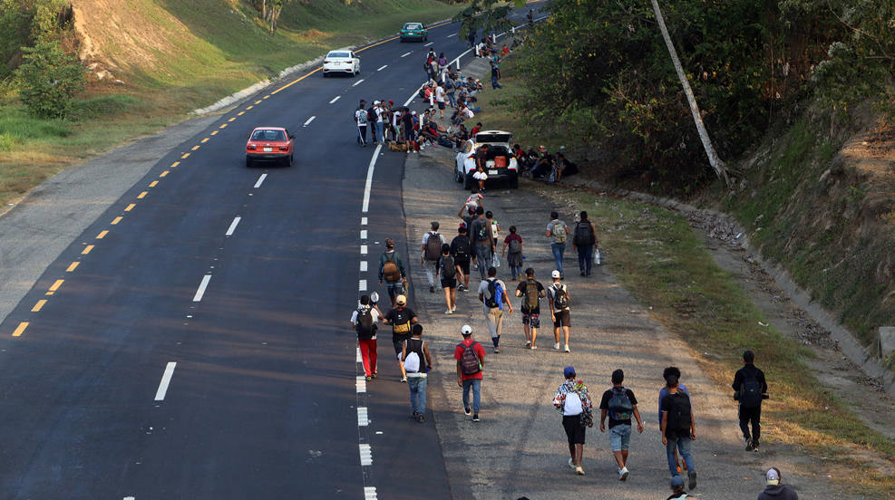 Migrantes caminan en caravana en una carretera de la ciudad de Huixtla (México). La primera caravana de 2023, que partió desde Tapachula con unos 1.000 migrantes, retomó la madrugada de este jueves su paso en el municipio de Huixtla, en Chiapas, sur de México. 