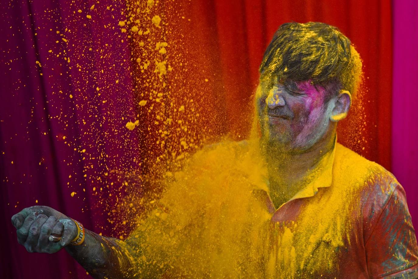 Un hombre reacciona al recibir una lluvia de polvos de colores durante las celebraciones del Holi en Chennai, India. El Festival Holi celebra la victoria del bien sobre el mal y marca la llegada de la primavera. 