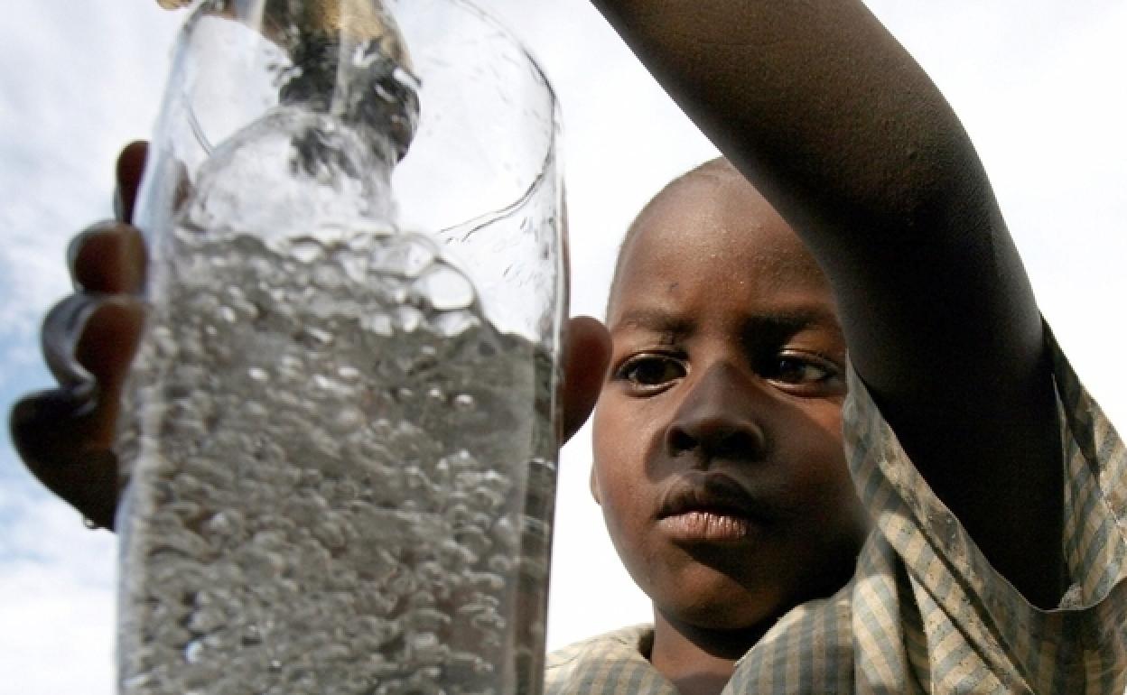 Un niño sudafricano coge agua de un grifo comunitario en el pueblo de Soweto.