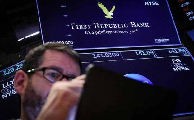 A trader on Wall Street with First Republic Bank quote screens.