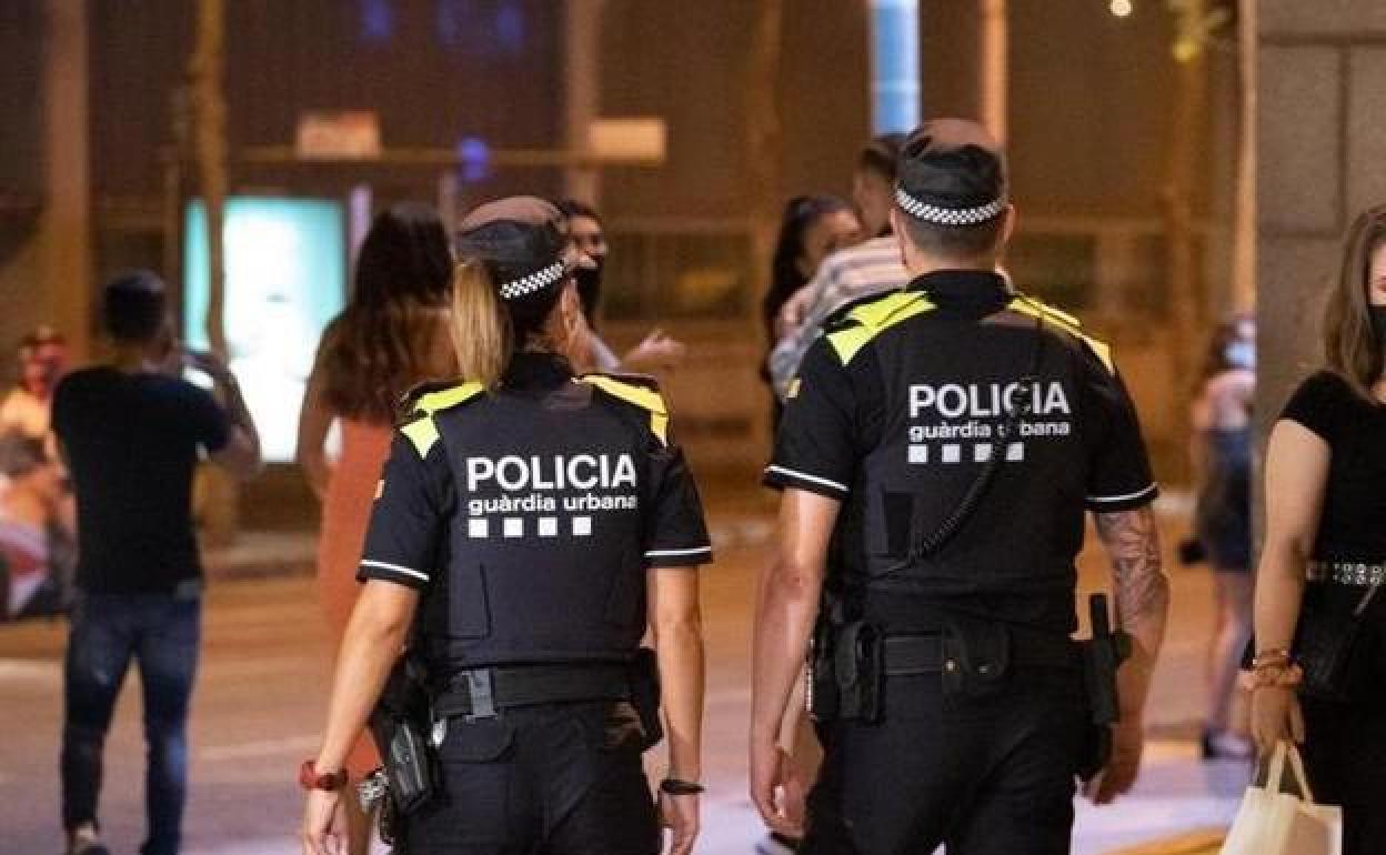 Una pareja de agentes de la Guardia Urbana de Barcelona en una patrulla por el centro de la ciudad.