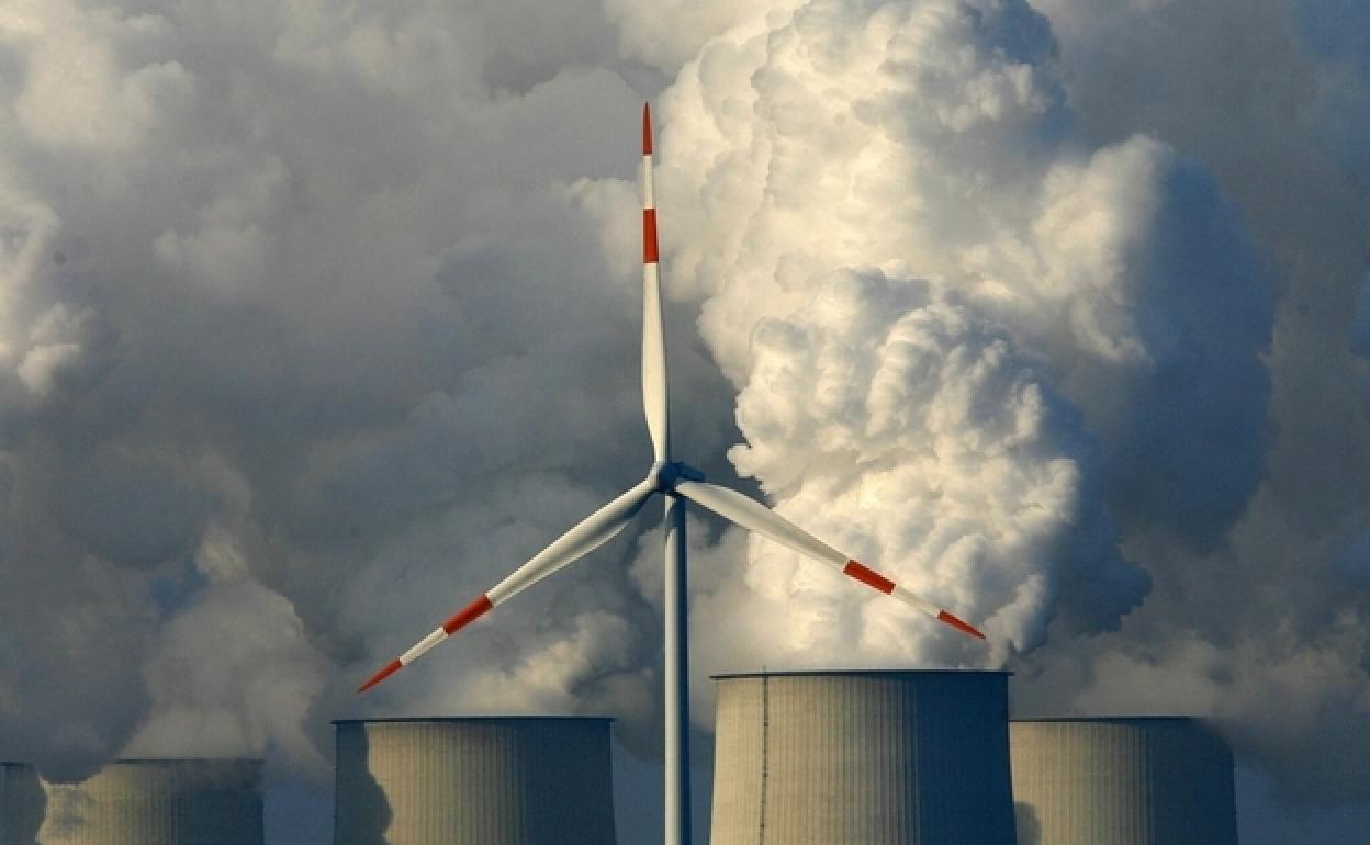 Aerogenerador ante las chimeneas de una planta de lignito en Jaenschwalde (Alemania).