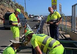 Operarios colocando las barreras tipo bionda junto al antiguo vallado.