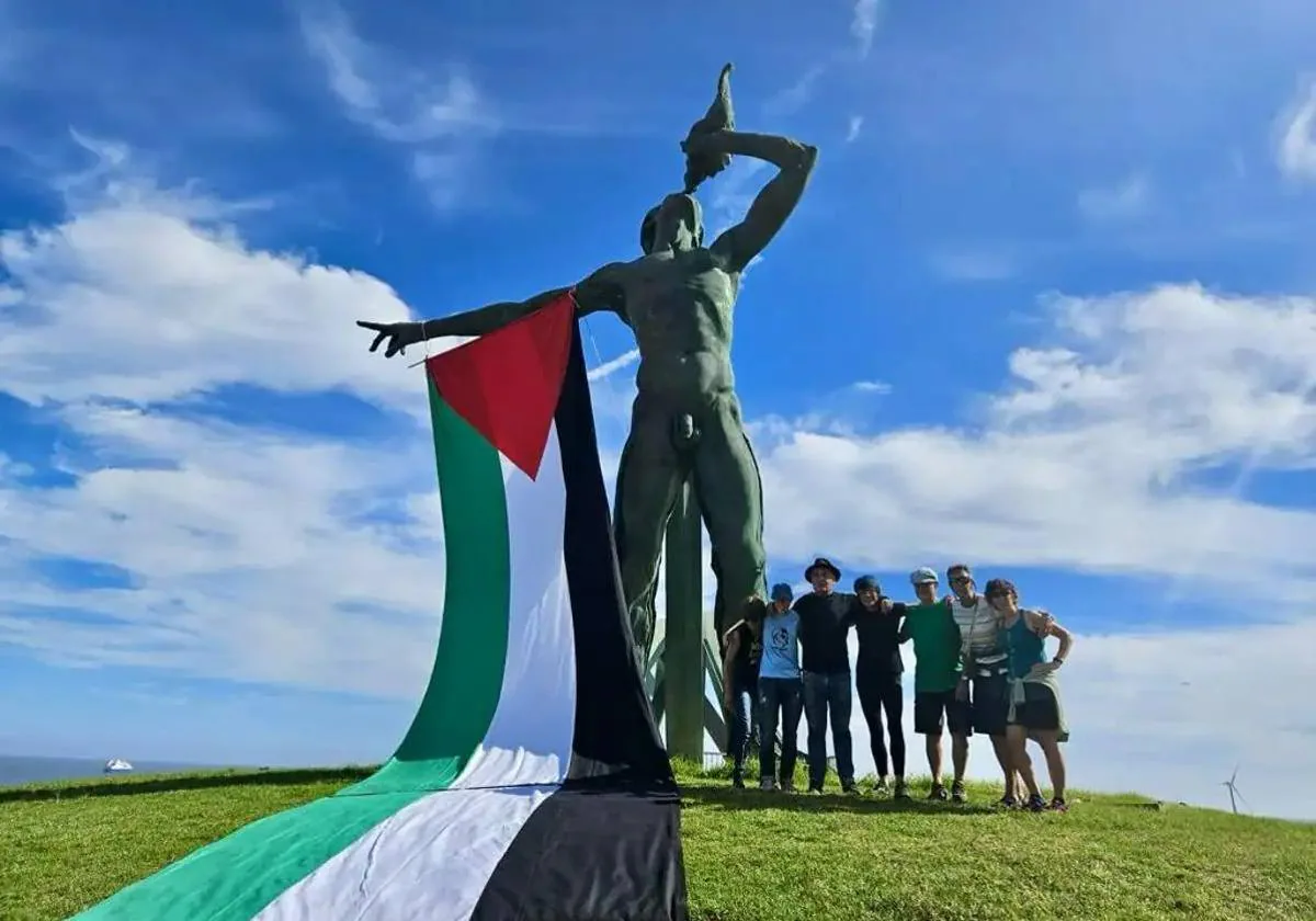 Activistas de Gran Canaria cuelgan en la obra Exordio el Tritón, en la capital grancanaria, la bandera de Palestina.