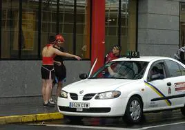 Imagen de archivo de unas mascaritas cogiendo un taxi.