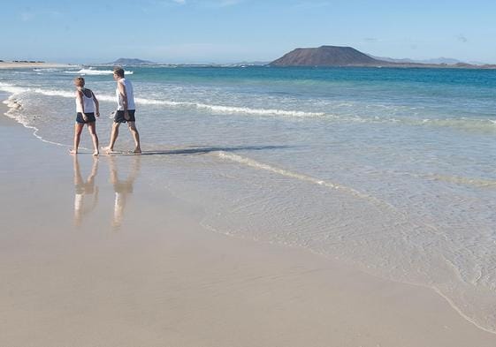 Dos turistas en las Grandes Playas de Corralejo, en el municipio de La Oliva.