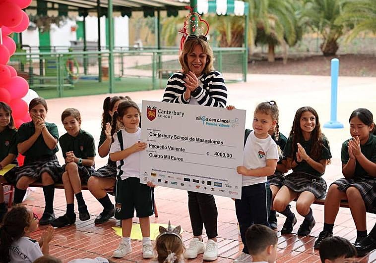 Dos alumnas del colegio entregan el cheque con la ayuda a la vicepresidenta de Pequeño Valiente, Montserrat Sánchez.
