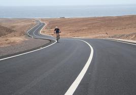 Un ciclista pasa por la nueva carretera que enlaza Parque Holandés con el semienlace de la autovía en dirección a Corralejo.