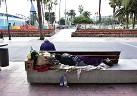 Una persona sin hogar duerme en un banco de Santa Catalina, en Las Palmas de Gran Canaria.
