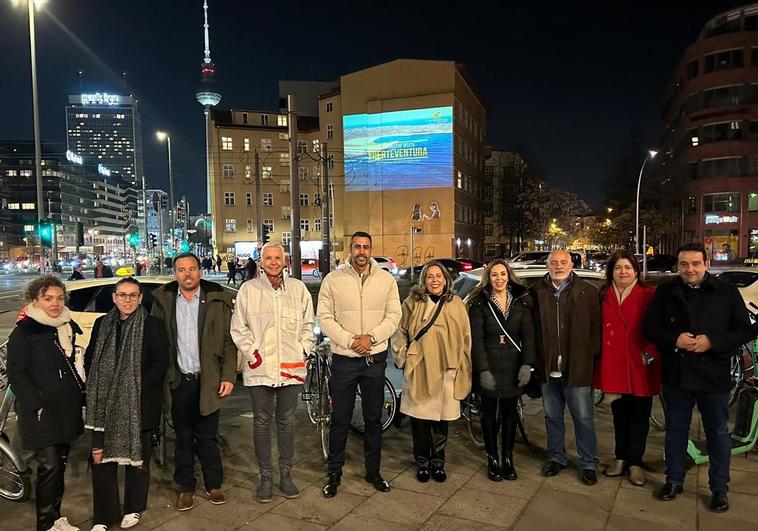 Jessica de León, consejera regional de Turismo, con alcaldes, concejales y miembros del Cabildo de Fuerteventura y de la Cámara de Comercio, en Alexanderplatz con una de las pantallas.