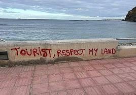 Graffiti de 'Turista respeta mi tierra' en la zona de El Palmar, Tenerife.