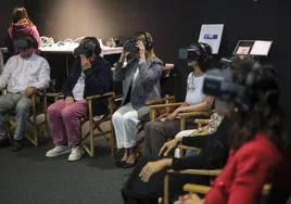 Algunas personas, con las gafas de realidad virtual, se disponen a distrutar del proyecto artístico.