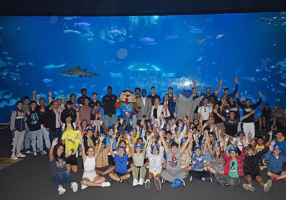 La plantilla del CB Gran Canaria, junto con estudiantes del CEIP La Zafra, IES Noroeste y el IES Punta Larga en el acuario Poema del Mar.