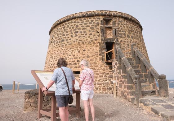 Turistas consultan la información sobre la torre defensiva, ya abierta al público.