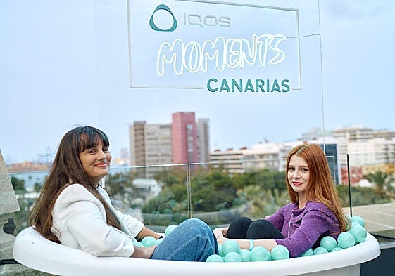 Imagen de dos chicas disfrutando de momonetos únicos IQOS.