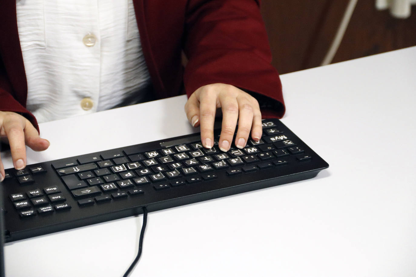 Al teclado le pone unas pegatinas especiales para mejorar su visión.