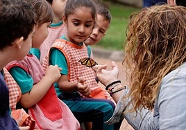 La concejala Gemma Martínez Soliño sostiene una monarca ante la mirada de los alumnos del CEIP Don Benito.